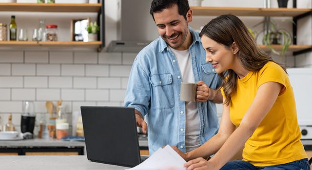 Man and woman in kitchen with laptop